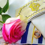 Wedding rings and roses on prayer shawl