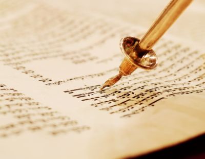 A yad (Torah pointer, literally hand) follows along in a Torah scroll unrolled at the Ten Commandments