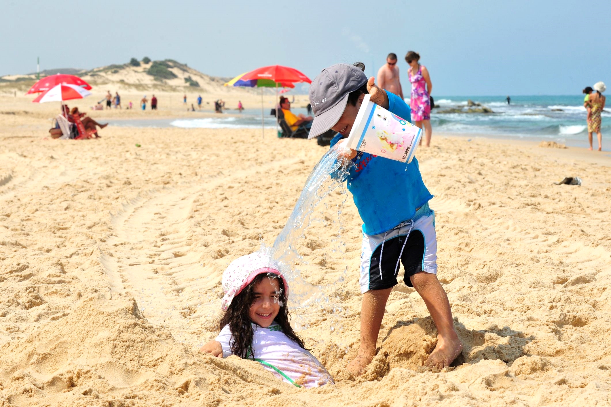 Israeli siblings play on a Mediterranean beach in Ashdod, Israel.