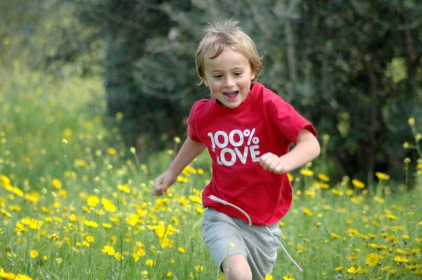 An Israeli boy runs through a meadow.