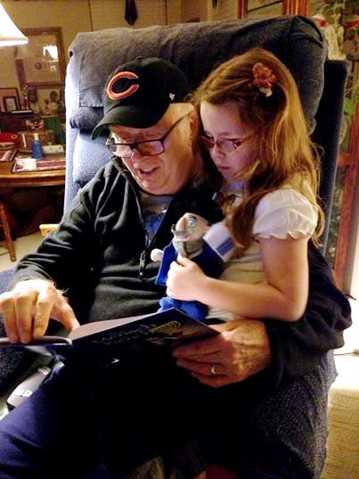 A father reads to his granddaughter the Mensch on a Bench story Hanukkah-Mench on a Bench-storytime