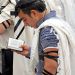 Jewish men wearing tallitot (prayer shawls) pray with tefillin (phylacteries) and siddurim (Jewish prayer books).