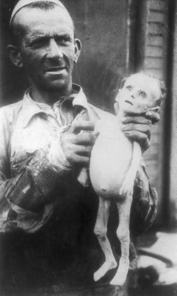 A man holds a Jewish infant who starved to death in Poland's Warsaw Ghetto. Photos such as this served to record the horrors of ghetto life for posterity.