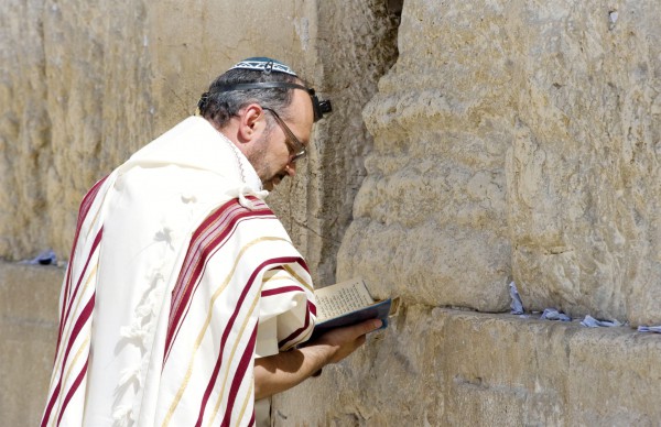 A Jewish man recites morning prayer (Shakharit) in Jerusalem at the Western Wall.