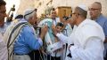 A 13-year-old Jewish boy carries the Torah scroll at the Western (Wailing) Wall as the adults venerate the Torah by kissing the Torah tik (ornate box protecting the Torah scroll).