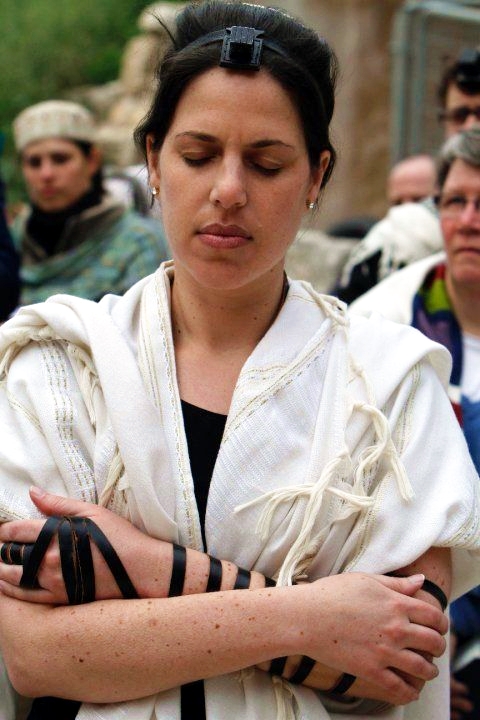 A Woman of the Wall (WOW) wears a tallit and tefillin as she prays.