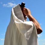 A Jewish man prays wearing a tallit (prayer shawl) and tefillin (phylacteries).