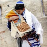 A 13-year-old Jewish boy pays respect to the Torah. (Ministry of Tourism photo taken by Yonatan Sindel, Flash 90)