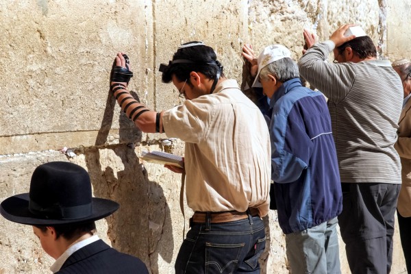 Jewish men pray in the men's section at the Western Wall.