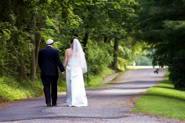 A Jewish bride and groom stroll together after the wedding ceremony.