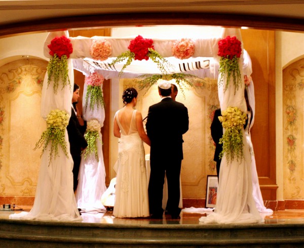 A Jewish bride and groom say their vows underneath the chuppah. (Photo by Greg Hirson)