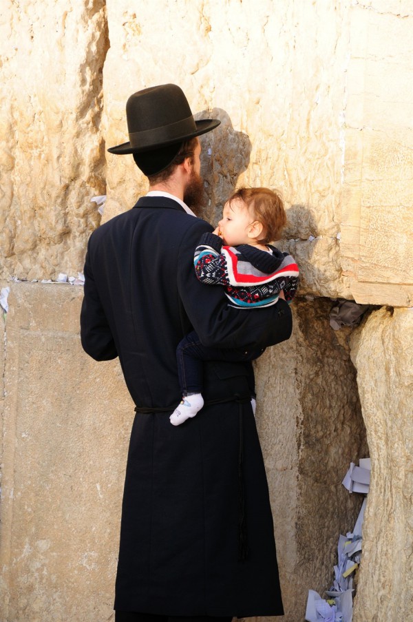 A Jewish father holds his child close as he prays at the Western (Wailing) Wall in the Old City of Jerusalem.