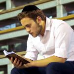 A Jewish man reads in the siddur (Jewish prayer book).