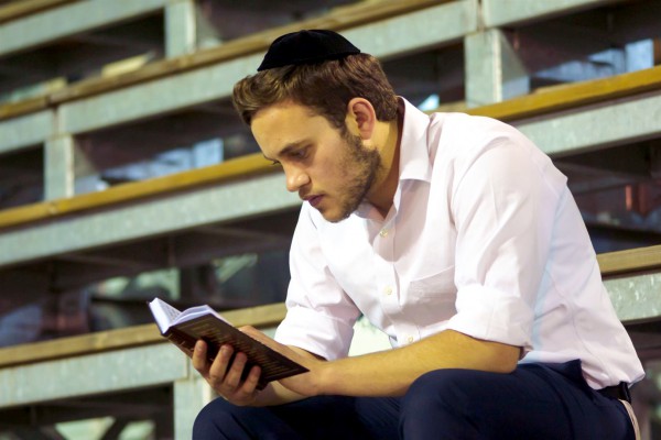 A Jewish man reads in the siddur (Jewish prayer book).