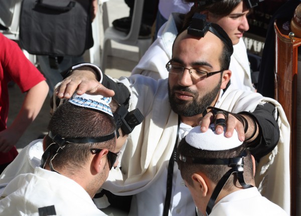 A blessing is recited over two Jewish youth at the Western Wall, also known as the Wailing Wall and the Kotel. (Photo by Kyle Taylor)