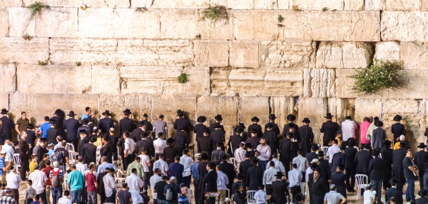 Jewish men pray in the men's section of the Kotel (Western or Wailing Wall)