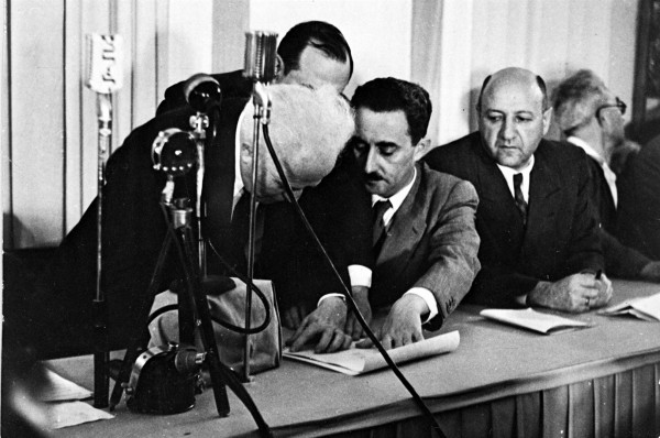 Ben Gurion signs Declaration of Independence, held by Moshe Sharet. 