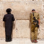 Orthodox Jewish man and Israeli soldier pray at the Western (Wailing) Wall