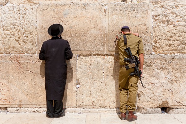 Orthodox Jewish man and Israeli soldier pray at the Western (Wailing) Wall