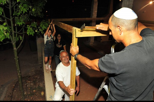 Israeli family builds sukkah.