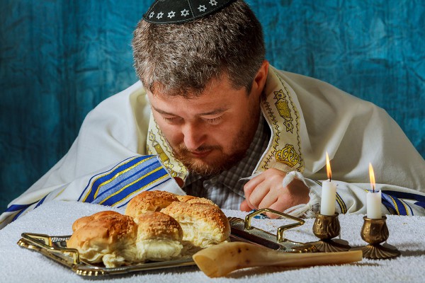 Jewish man prays a blessing over the challah (bread for Shabbat).