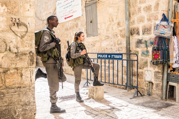 Woman soldier is guiding one of Israel's streets along with her male comrade.